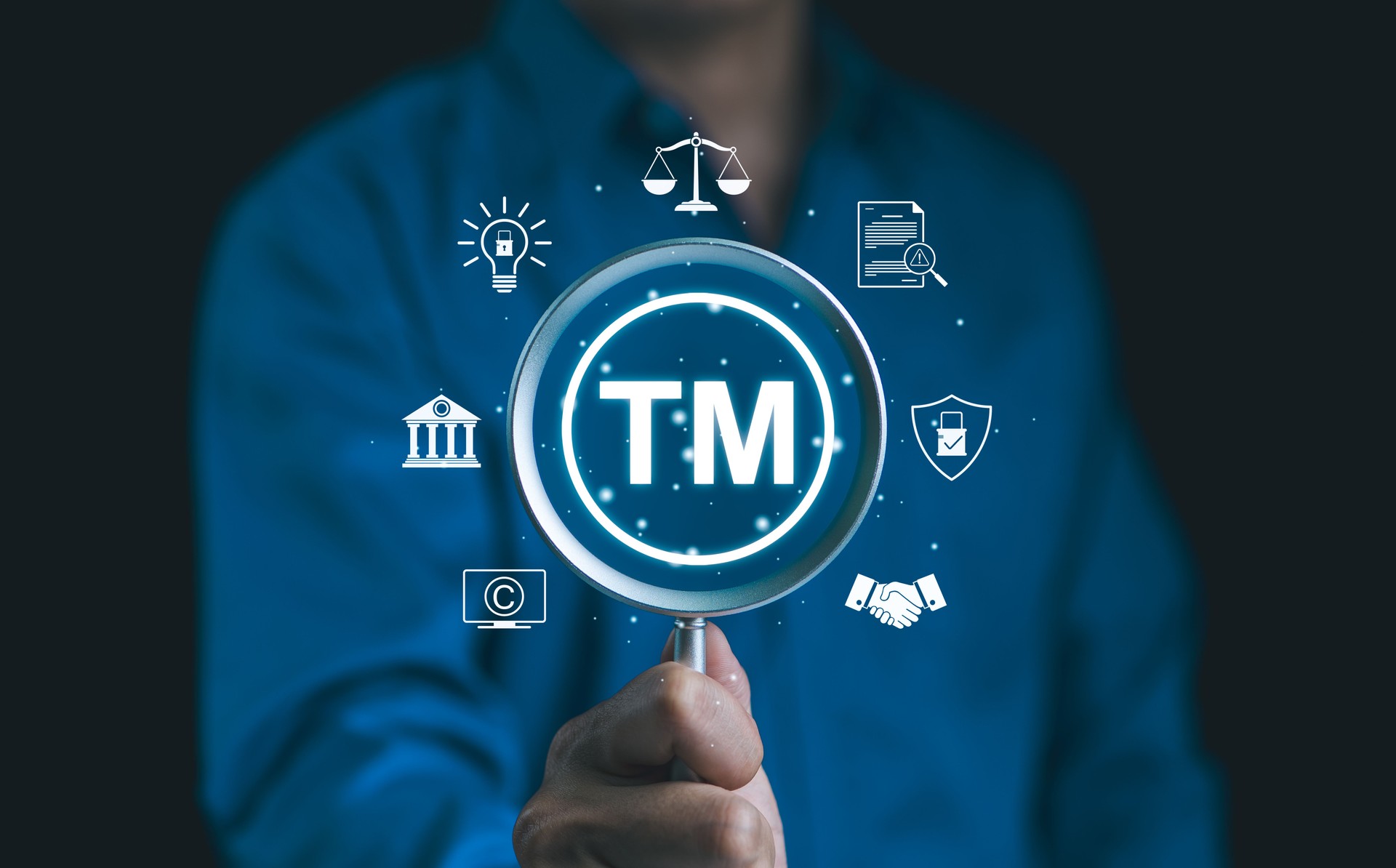 TM, Trademark protection, Intellectual property concept. Person holding magnifying glass with "TM" symbol, icons of intellectual property, legal protection, patents, copyright, and trademark security.